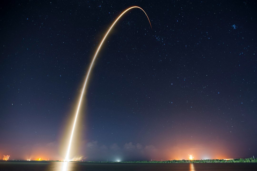 Long exposure of a rocket launch trail arcing across the night sky