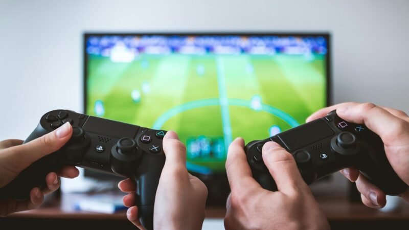 Hands holding video game controllers side by side
