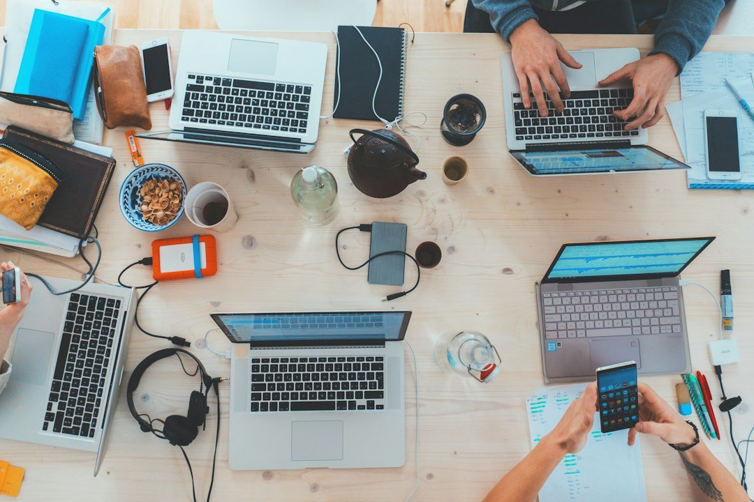 People seated at a table with laptops working