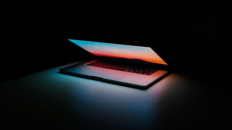 Laptop computer lit under stage lighting at a keynote presentation