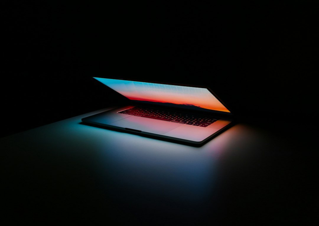 Laptop computer lit under stage lighting at a keynote presentation