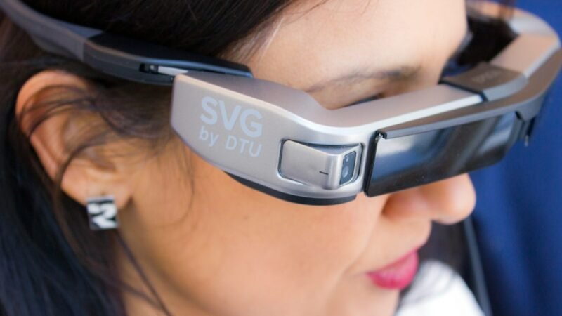 Person wearing smart glasses outdoors representing camera equipped wearable devices