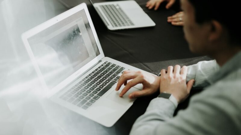 Man sitting at a desk using a laptop web browser