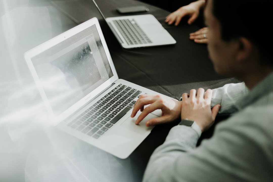 Man sitting at a desk using a laptop web browser