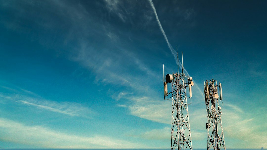 Cellular communications tower against a blue sky