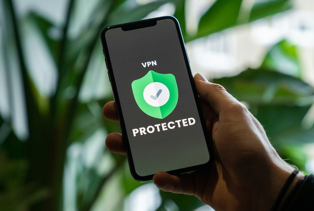 Hand holding an iPhone with a VPN privacy service enabled on screen