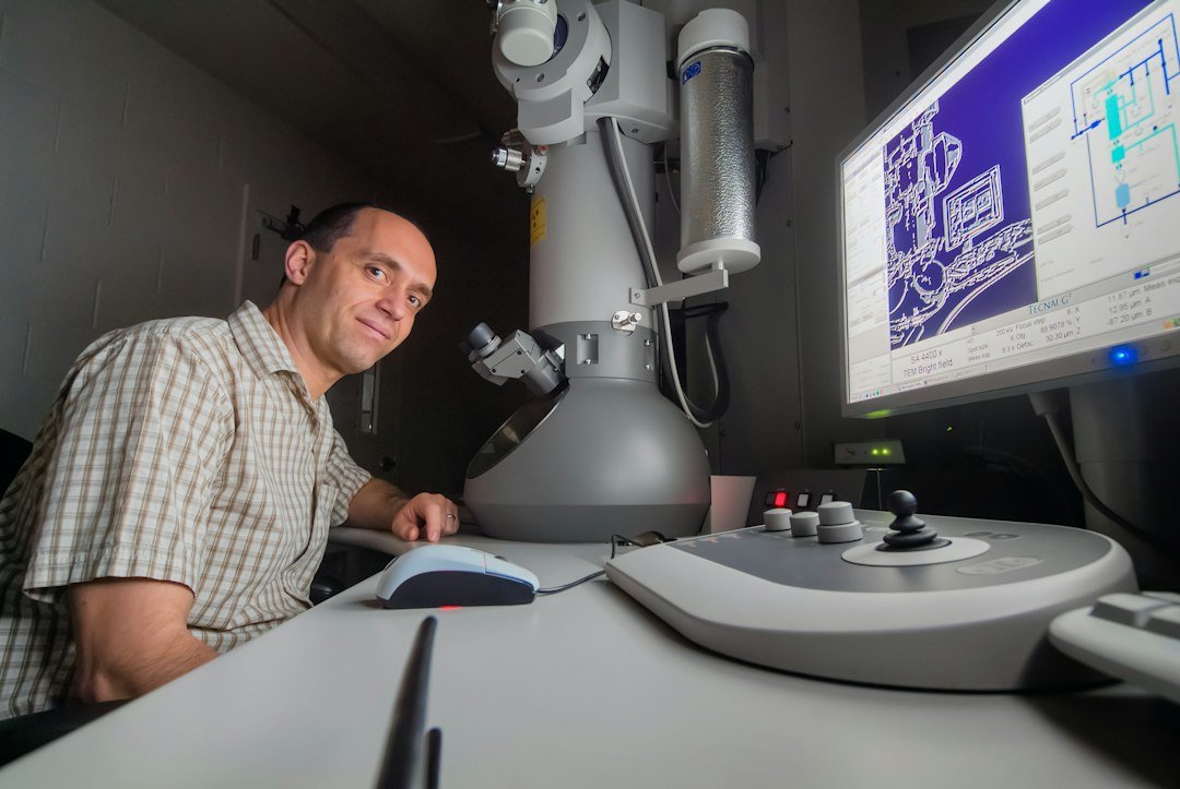 Researcher working with an electron microscope in a robotics and AI lab