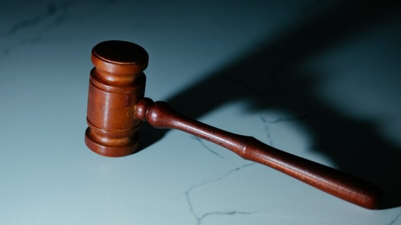 Wooden judge's gavel resting on a table in a courtroom