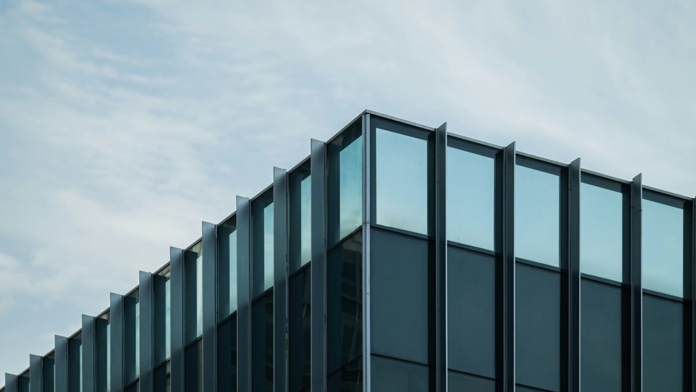 Blue glass corporate office building representing OpenAI's public response to its fired researchers