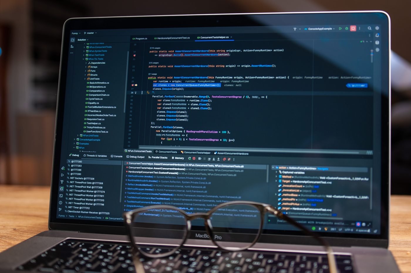 Laptop screen showing code in a debugging tool next to a pair of glasses