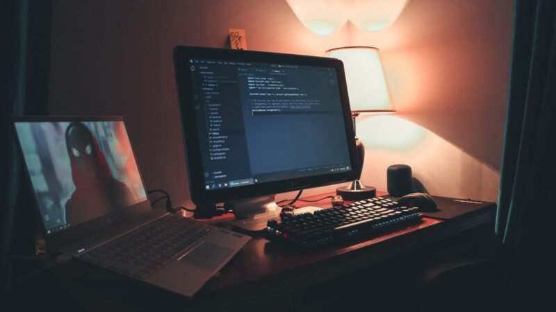 Warmly lit home office with dual monitors set up for coding