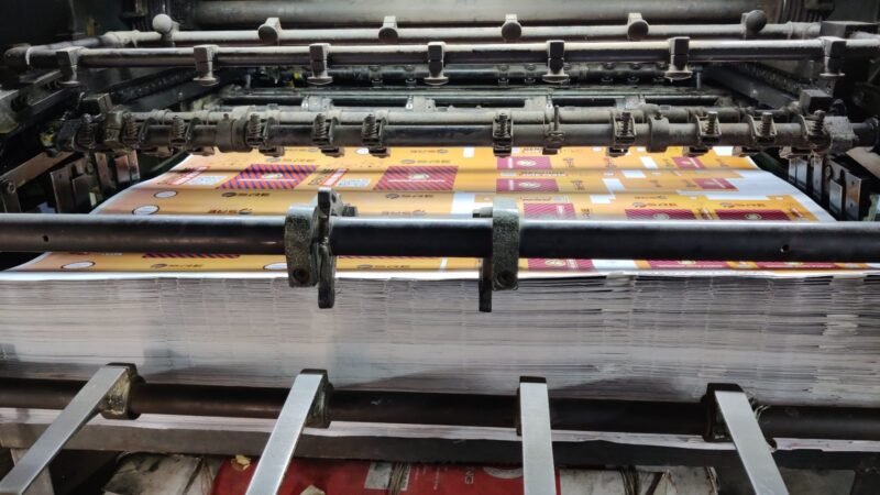 Offset printing press running brightly colored printed sheets