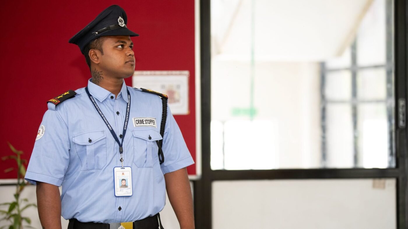 Uniformed security guard standing alert at a building entrance