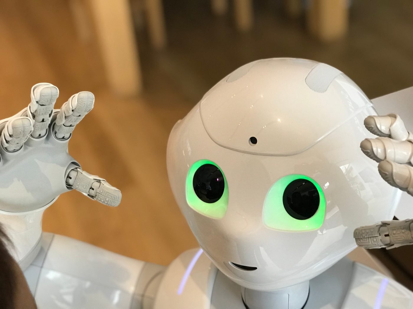 Humanoid robot with glowing green eyes in a modern indoor setting
