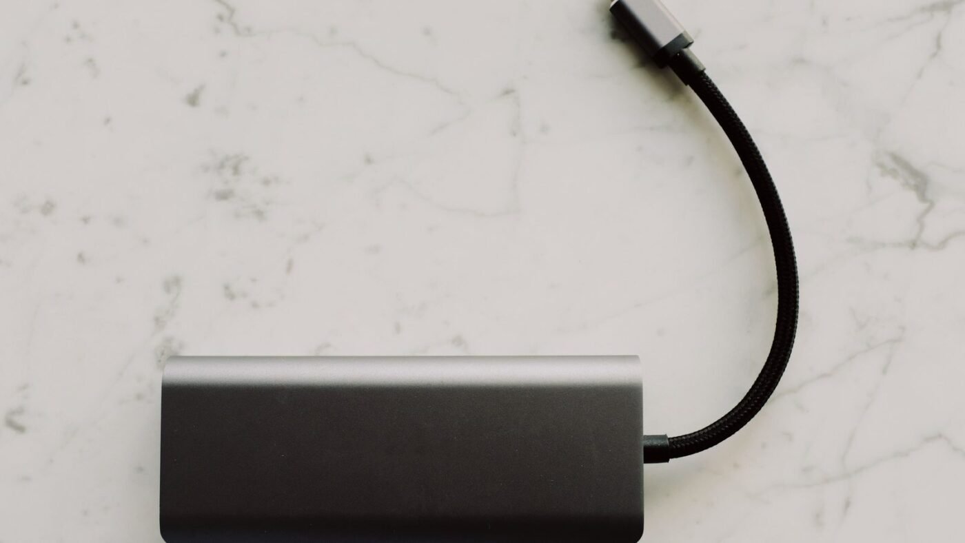 A USB-C hub with a braided cable on a white marble surface