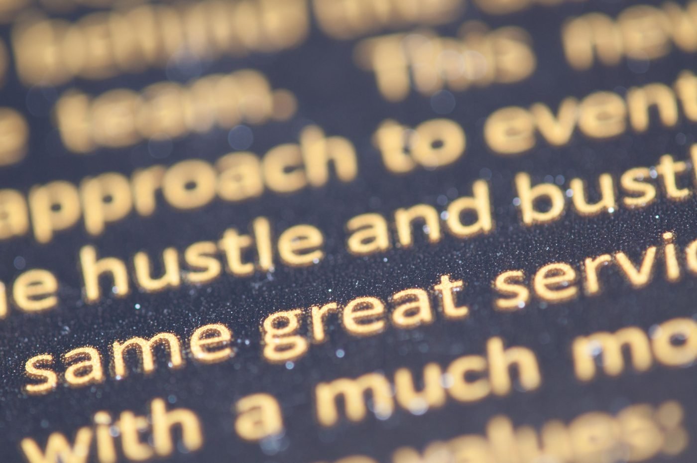 Macro shot of golden serif text on a dark background