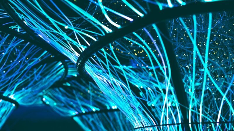 Glowing blue optical fibers forming a futuristic network
