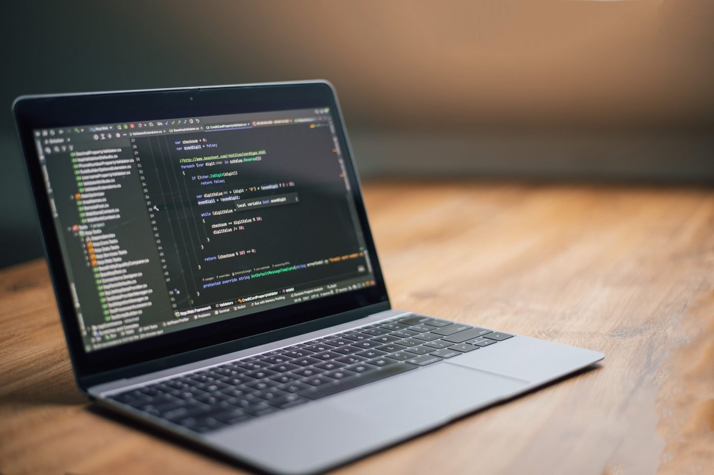 Laptop showing programming code on a wooden table