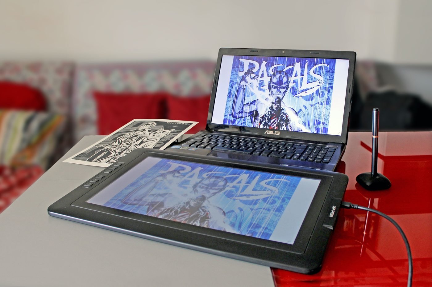 Laptop and drawing tablet displaying digital artwork on a desk