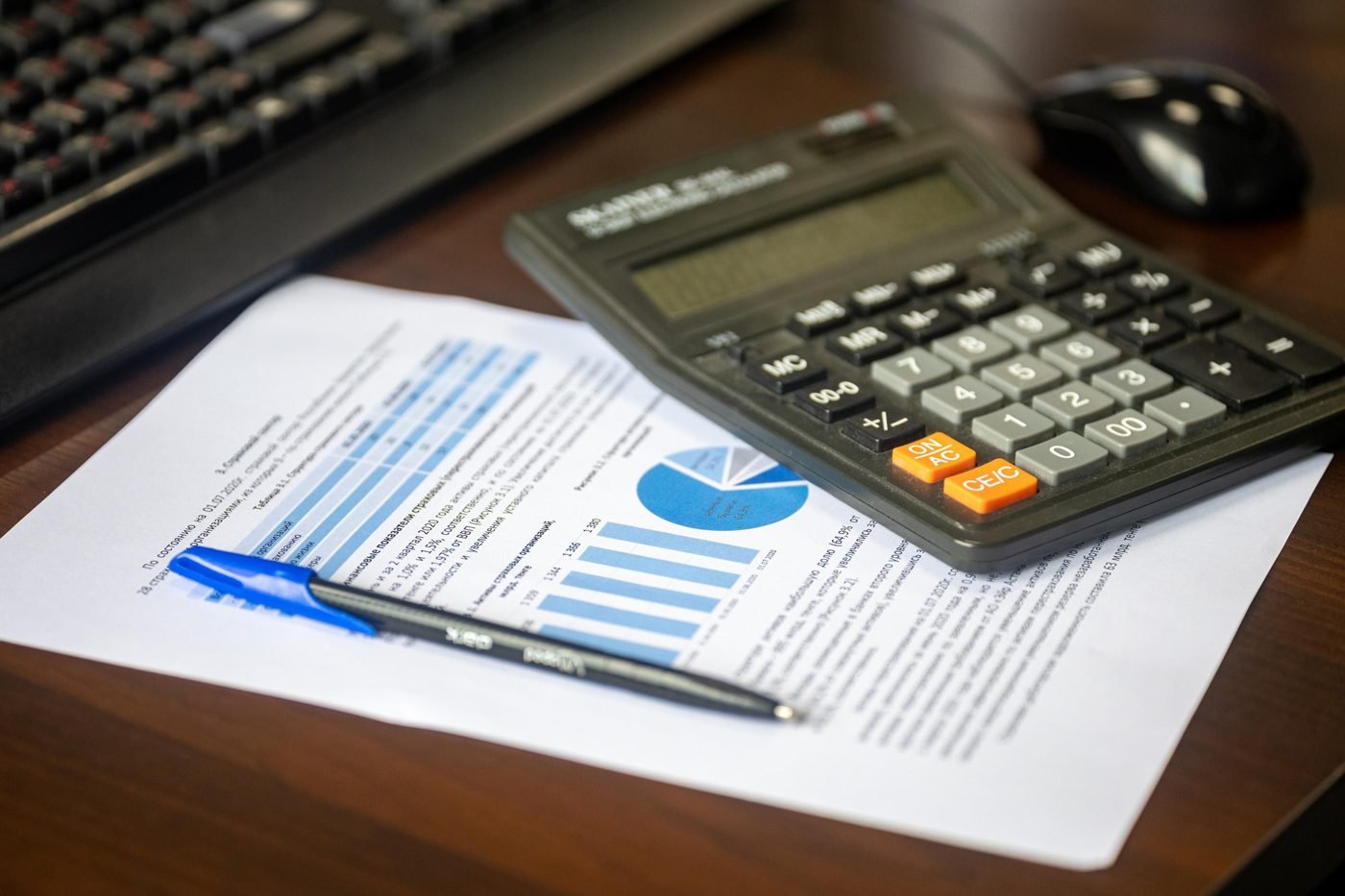 Desk with calculator, financial report and pen for business accounting
