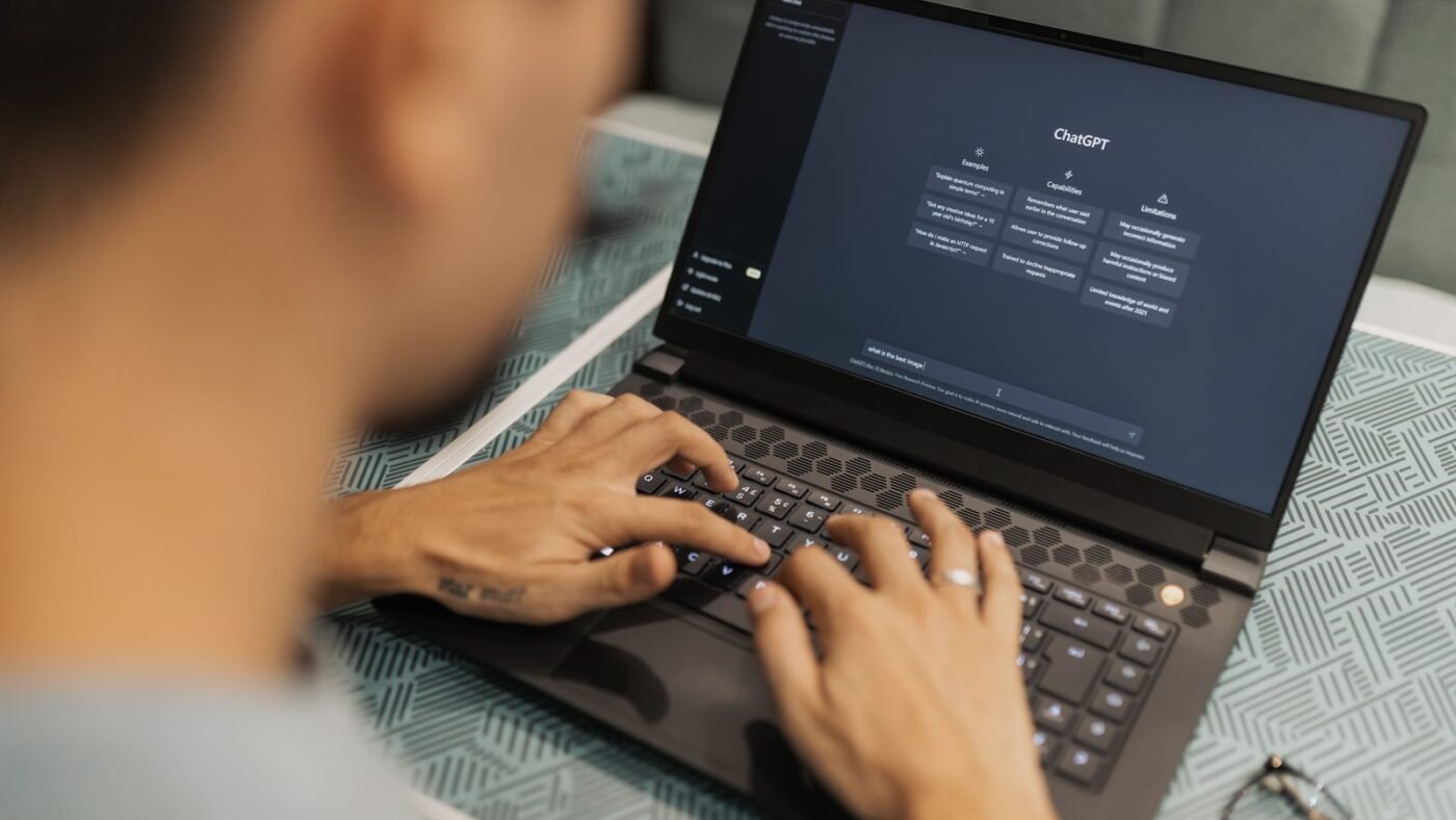 Man typing on a laptop running an AI chatbot interface