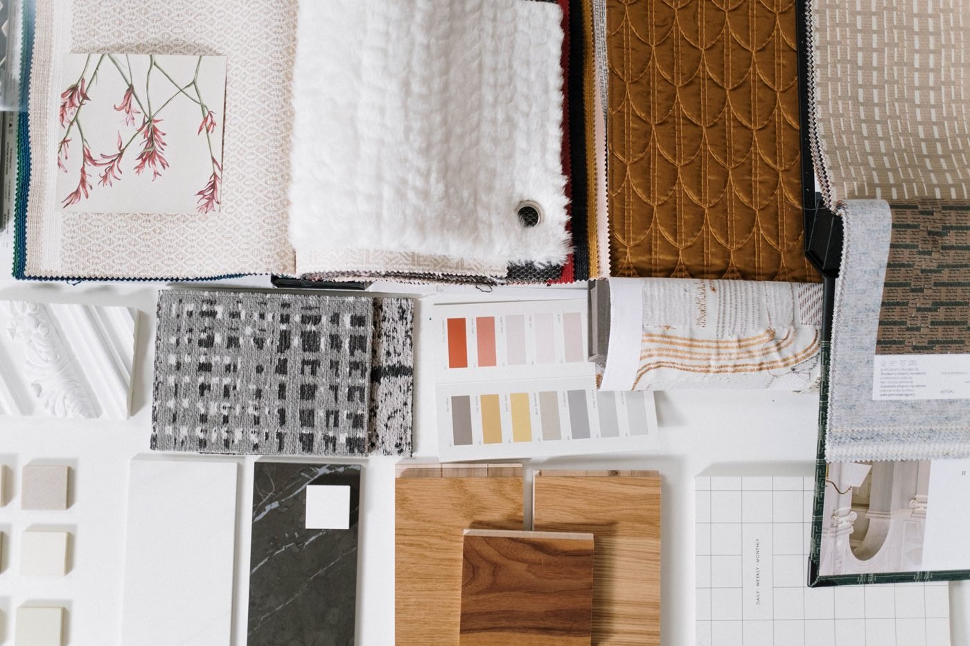 Flat lay of fabric swatches, tiles, color chips and material samples for a design project