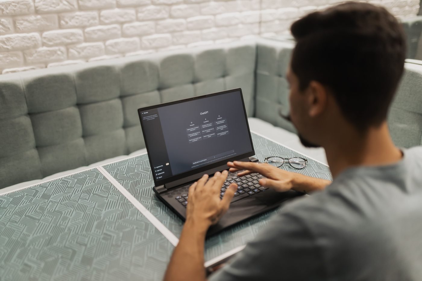 Man typing on a laptop showing an AI chat interface