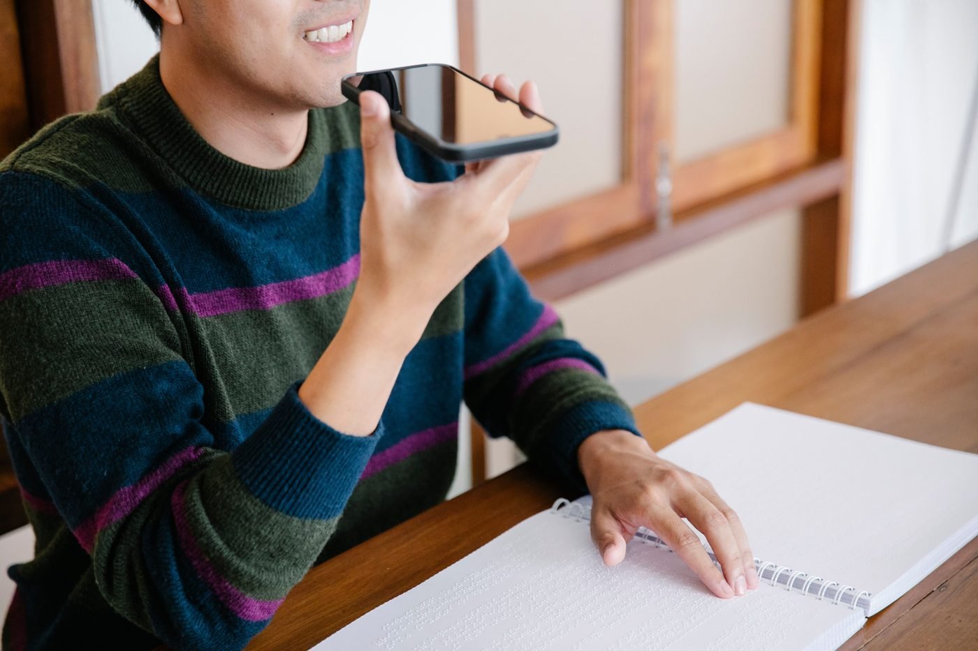 Man speaking a voice command into his smartphone at home