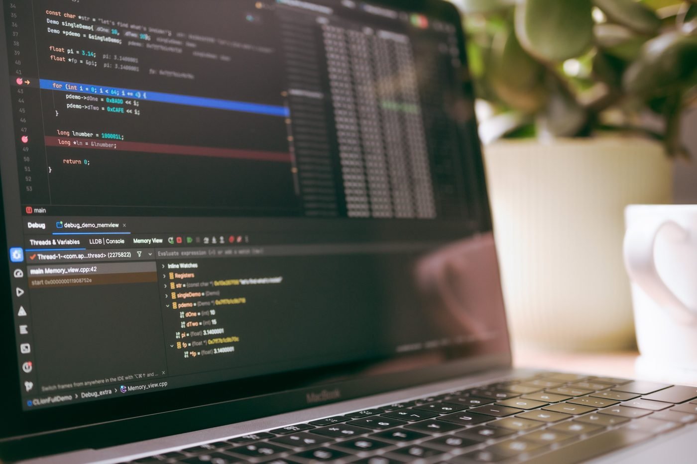Laptop screen showing programming code and debugging tools