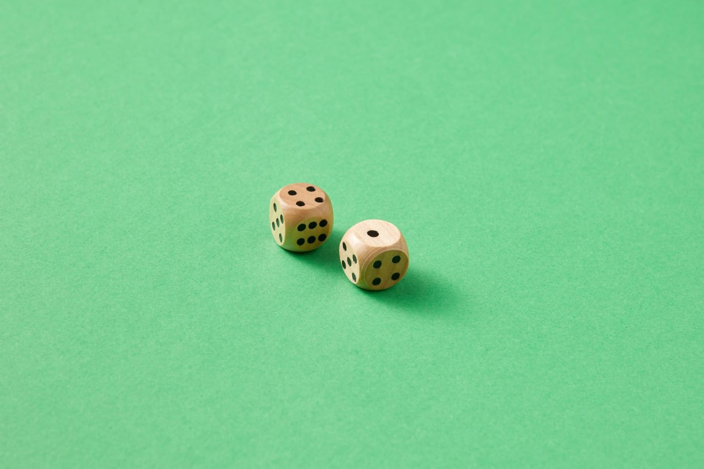 Two wooden dice on a bright green background