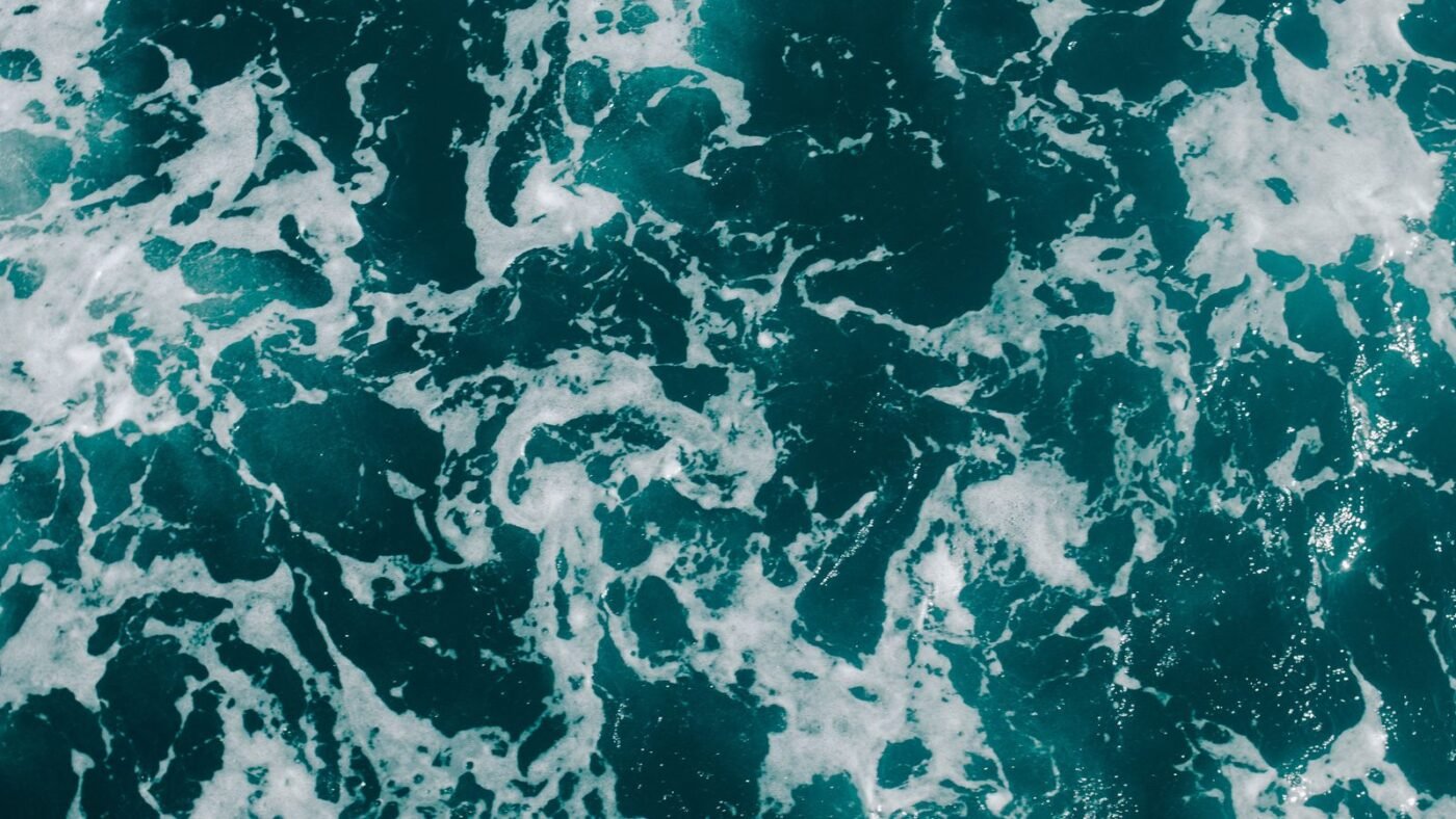 Aerial view of ocean waves with white sea foam