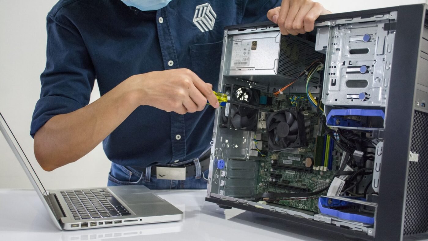 Technician repairing a desktop computer indoors