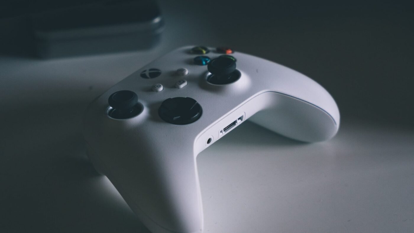 White Xbox wireless controller resting on a dark grey desk surface