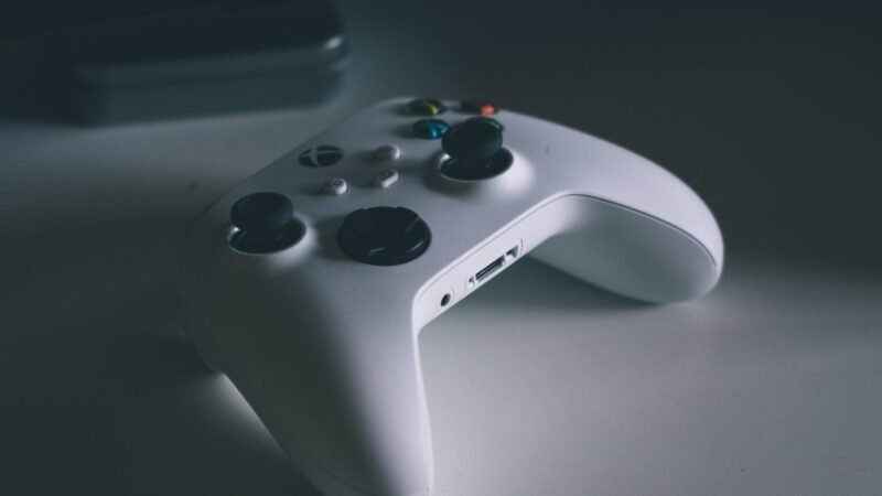 White Xbox wireless controller resting on a dark grey desk surface