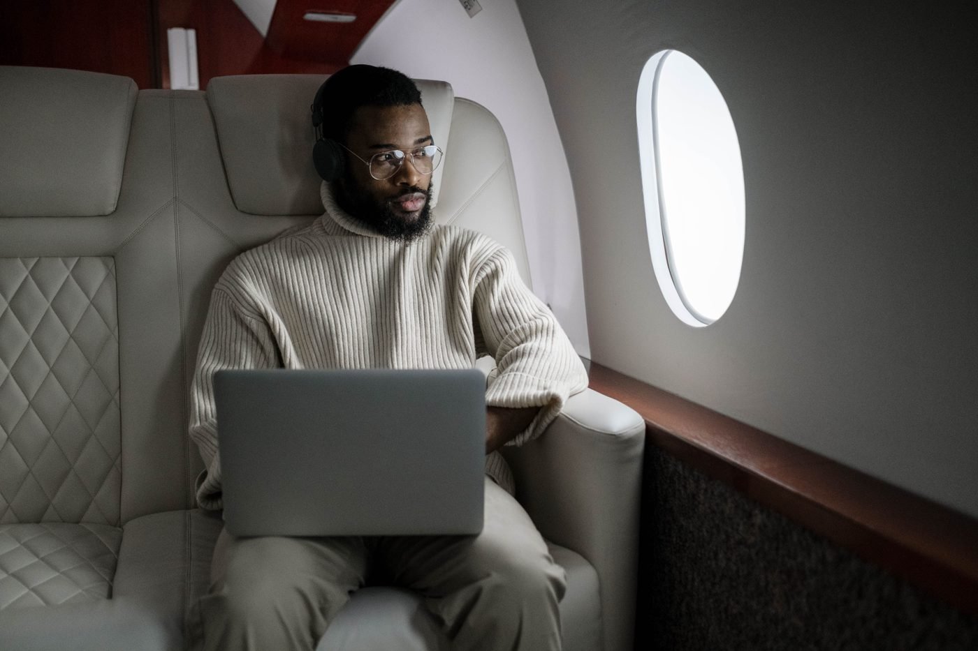 Man using a laptop in an airplane cabin seat