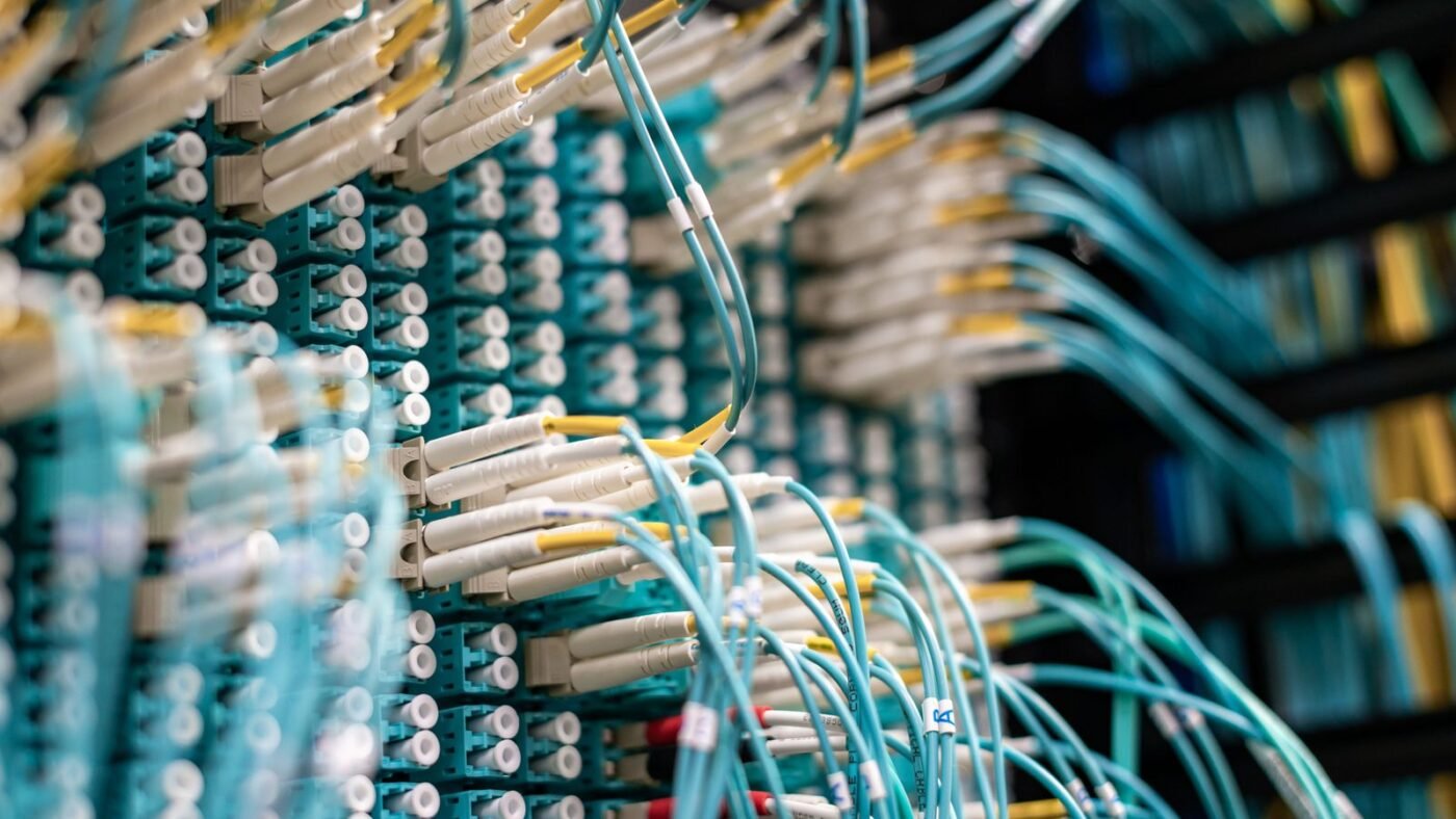 Dense bundles of fiber optic cables plugged into a data center patch panel