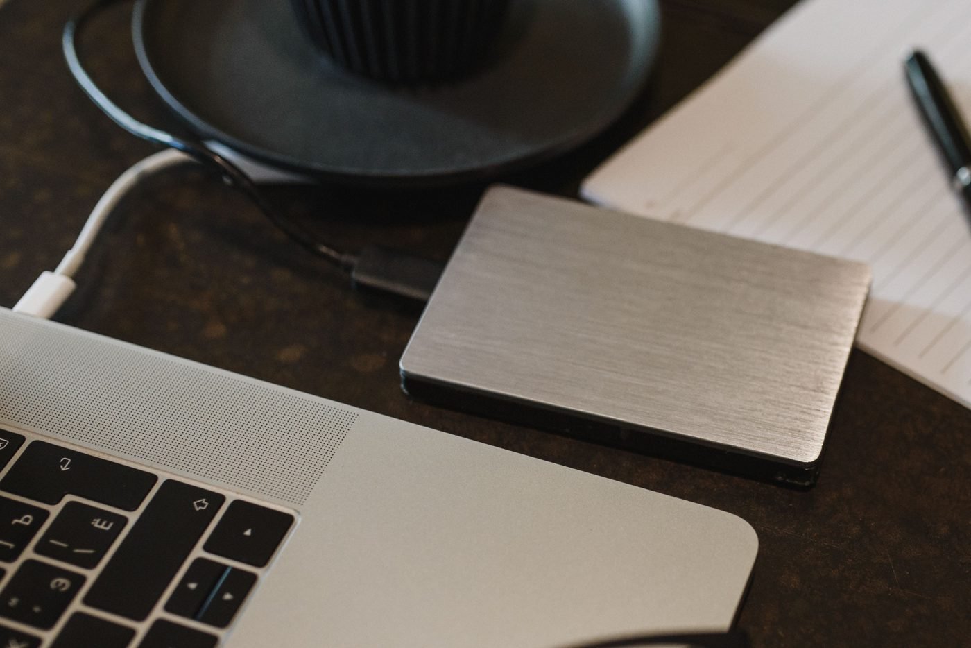 External backup hard drive connected to a laptop on a desk